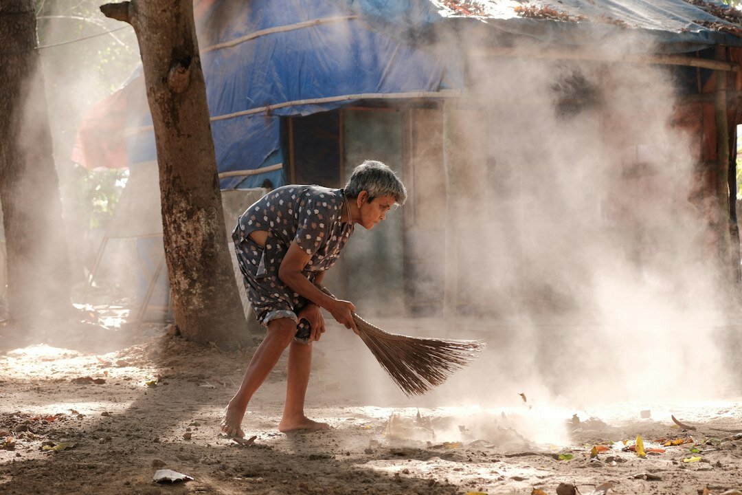 elderly man sweeping street