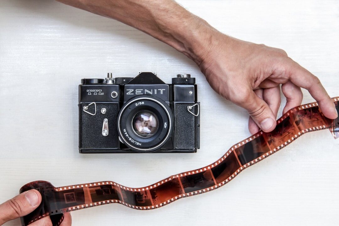 Close-up of hands holding a vintage analog film camera