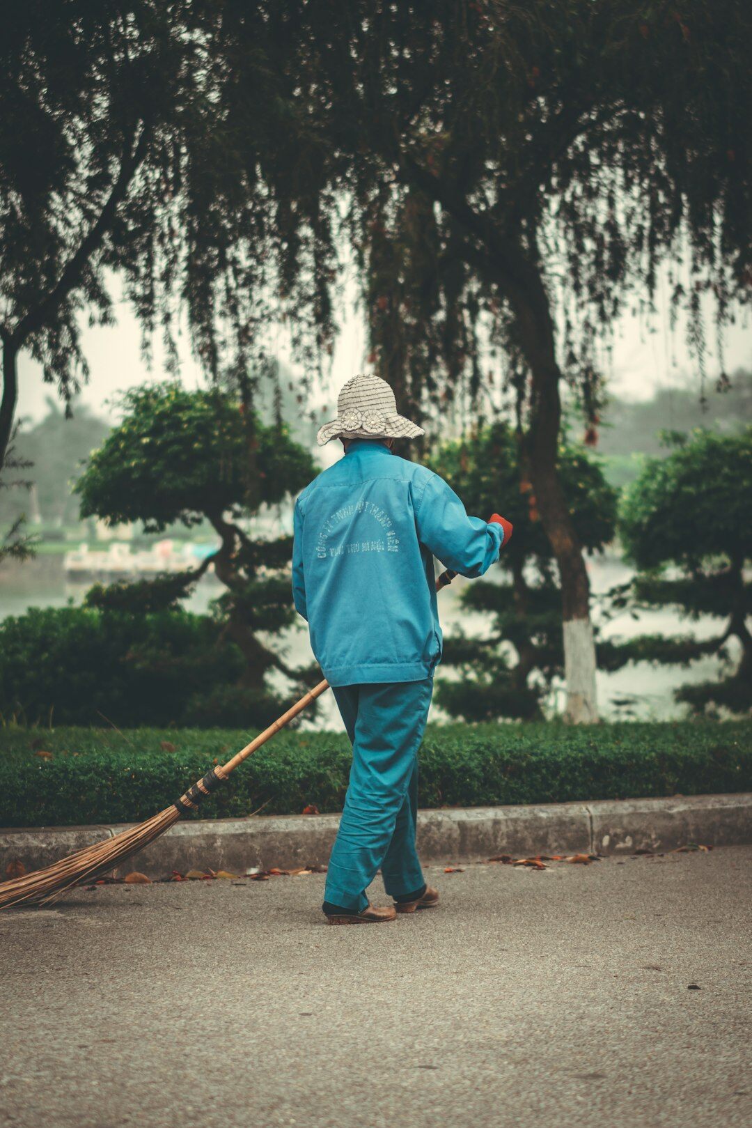 elderly man sweeping street